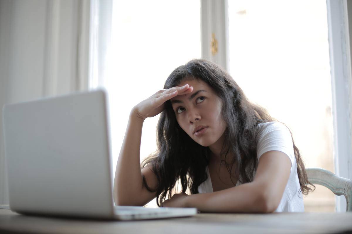 A frustrated woman sits at a computer.