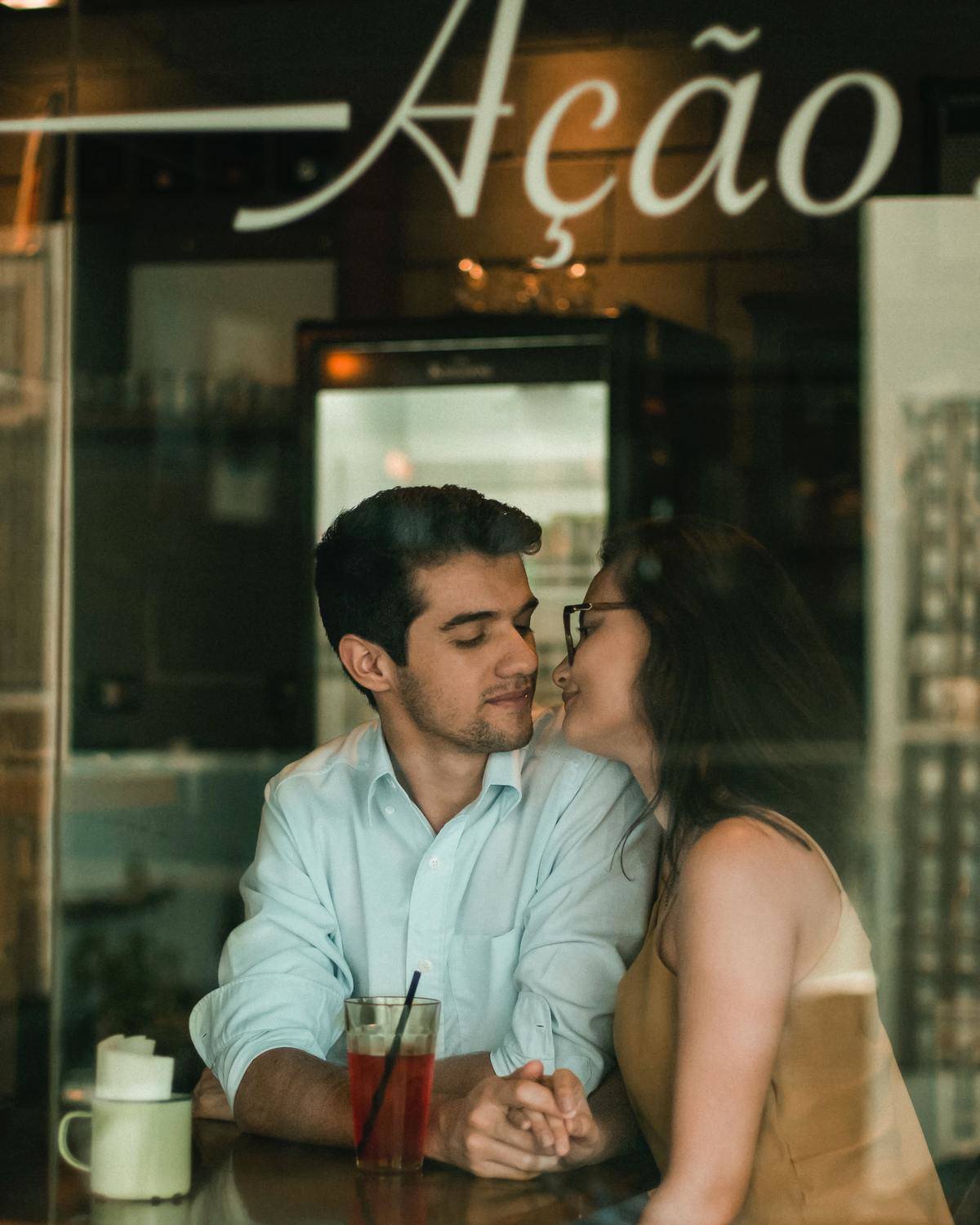 Couple leaning in for a kiss in a restaurant 