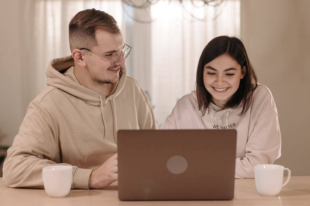 Couple looking at laptop together woman smiling 
