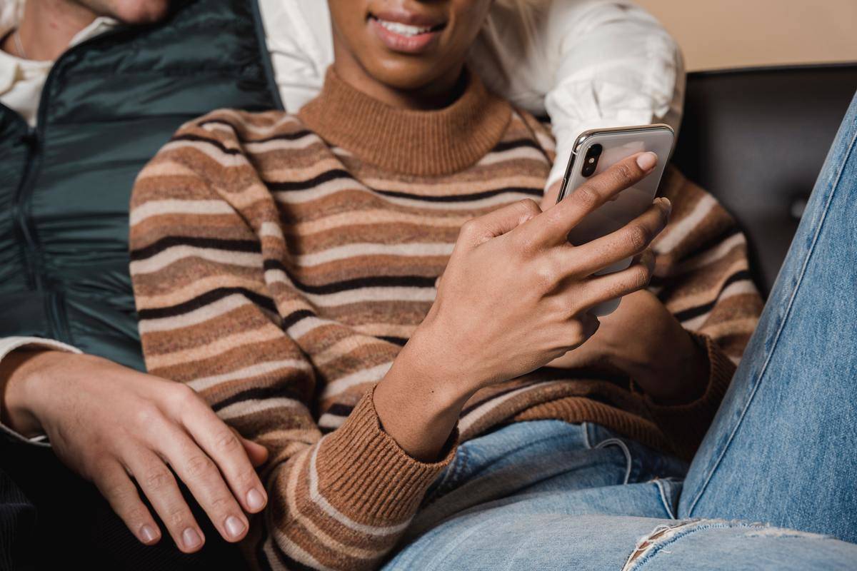 Couple sitting on couch woman texting