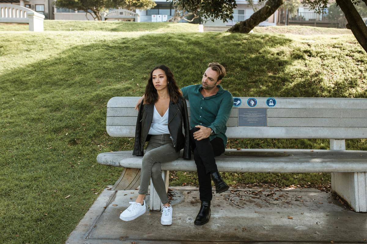 Couple sitting on bench man looking at woman