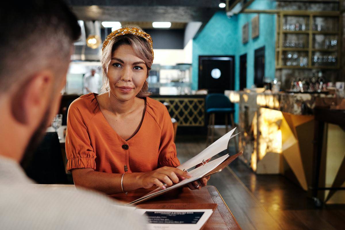Woman looking at man over table during date