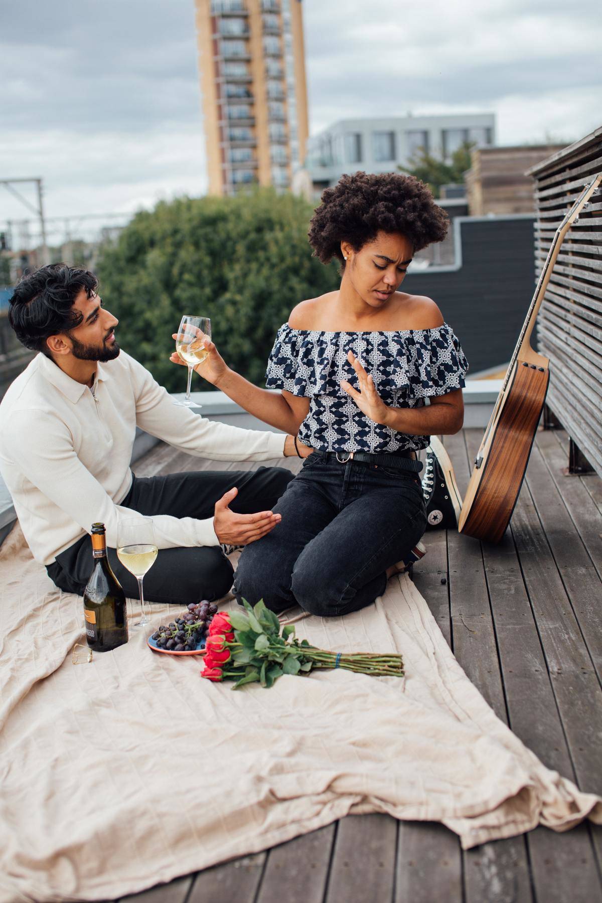 Couple on picnic date, woman looks annoyed