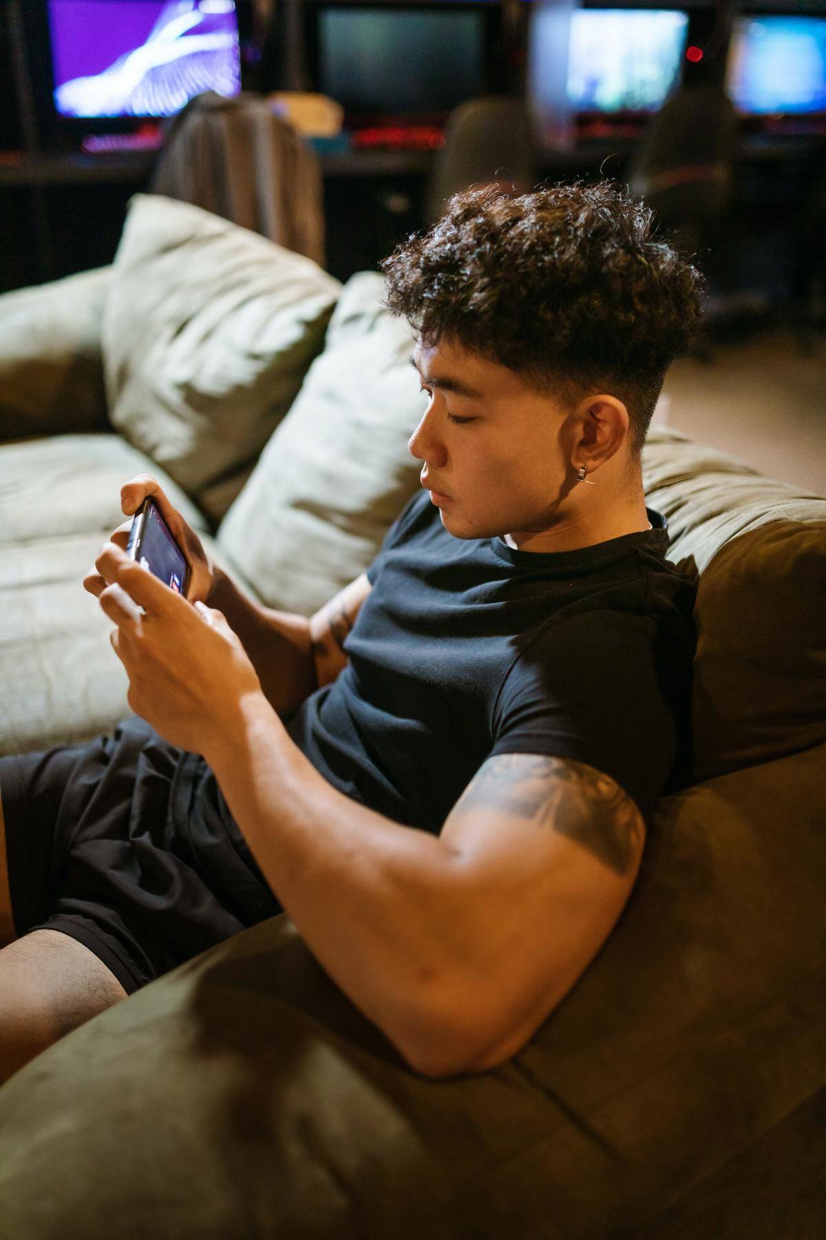 Man sitting on couch watching video on phone