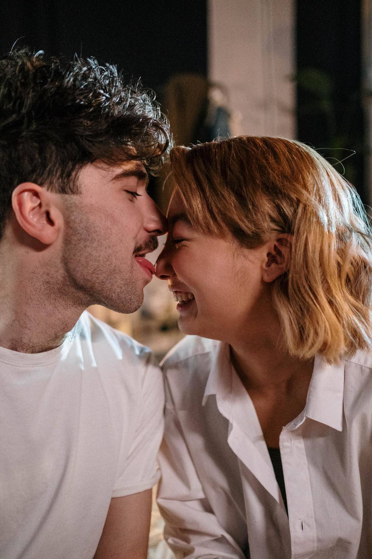 Couple laughing while man licks woman's nose 