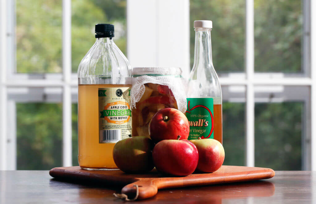 ACV and apples on serving board photographed in kitchen