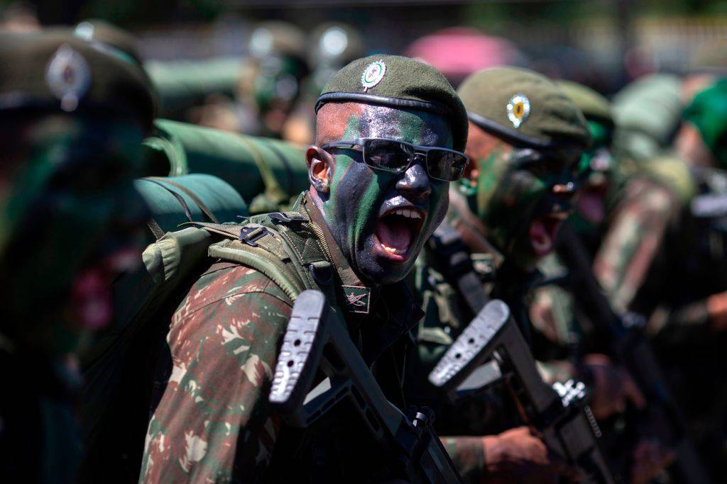 Brazilian soldier wearing face paint shouts at person in crowd