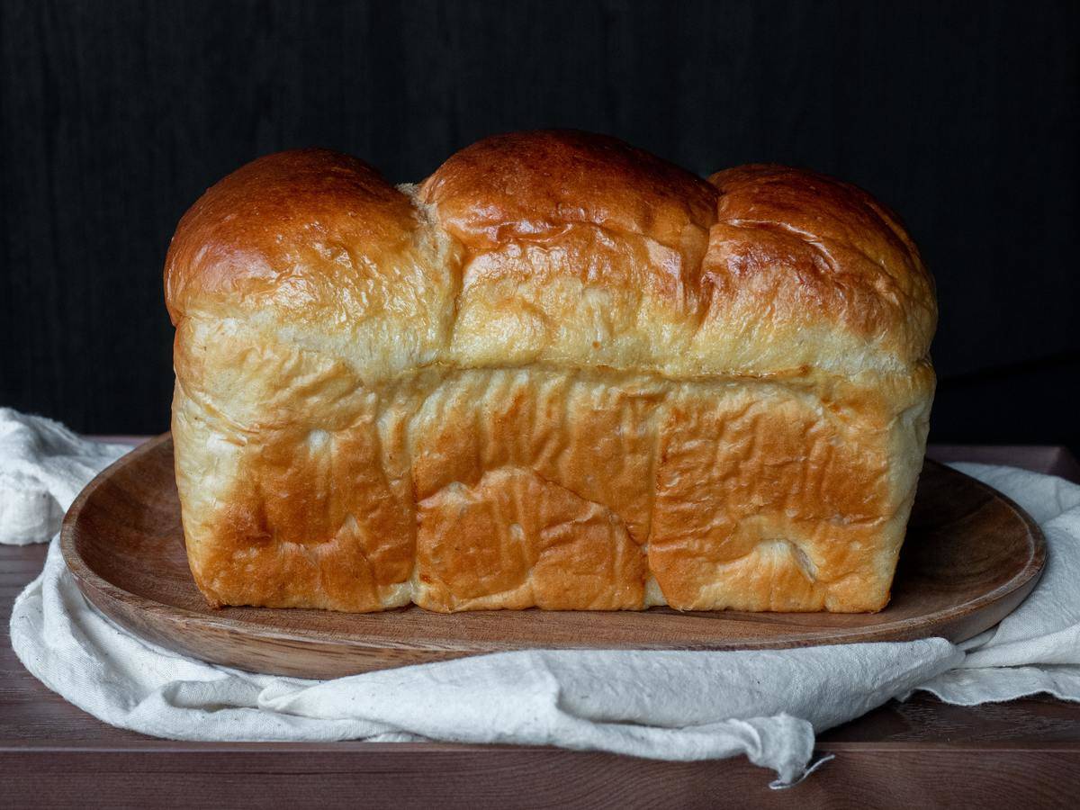 Sourdough brioche on a wooden plate.