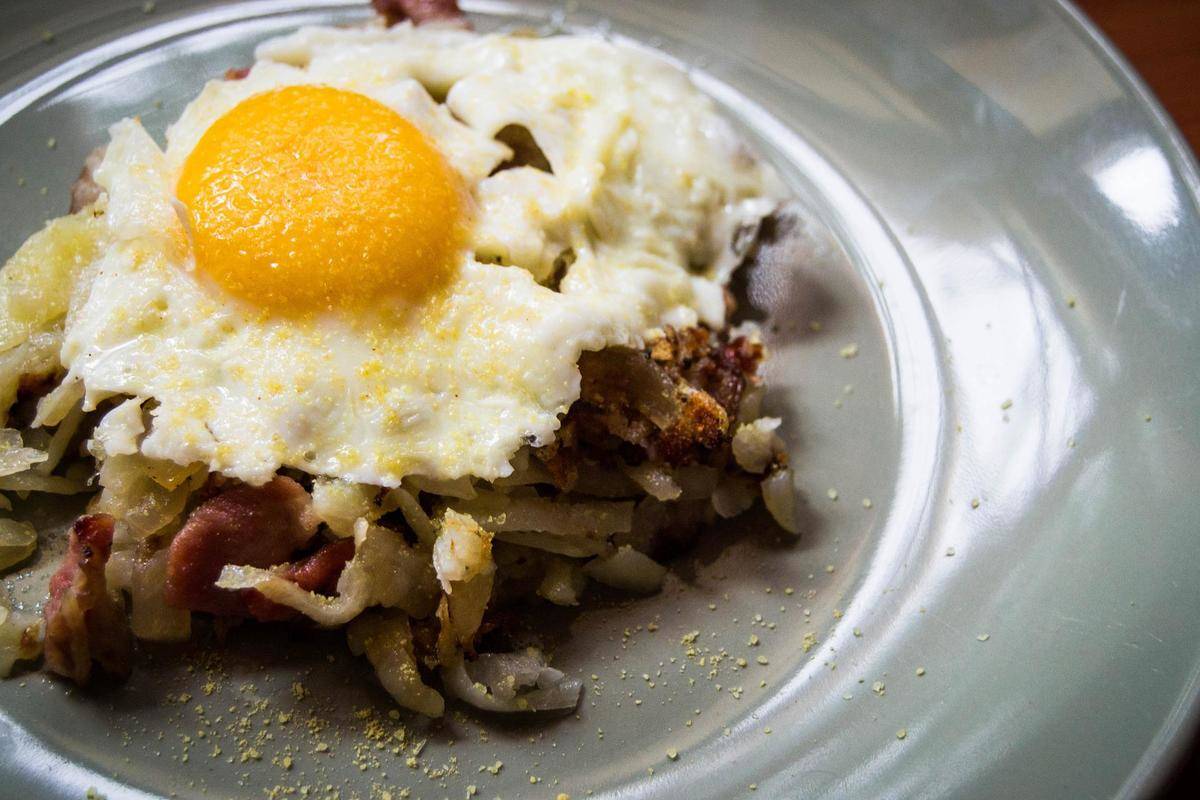 Close up of a sunny side egg on top of hash browns.