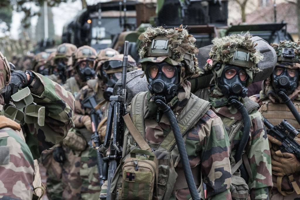 French soldiers wearing gas masks stand in a group