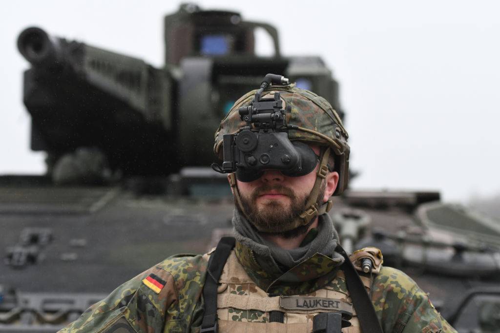 German soldier looks out special operations glasses with tank in background