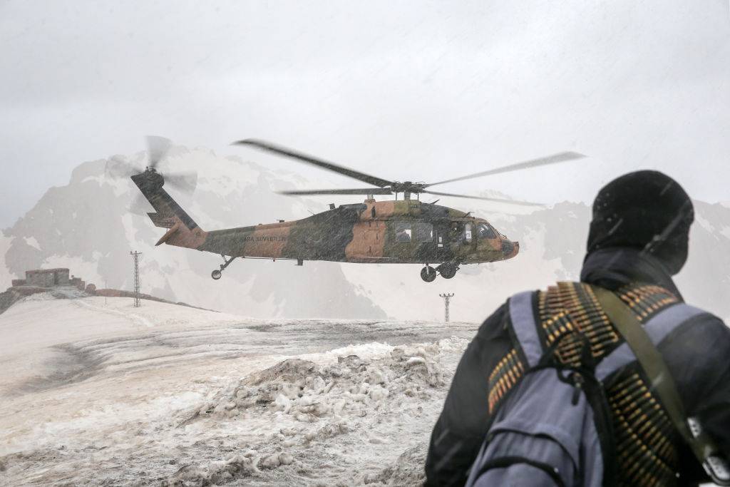 Soldier looks at helicopter landing through sand/dust