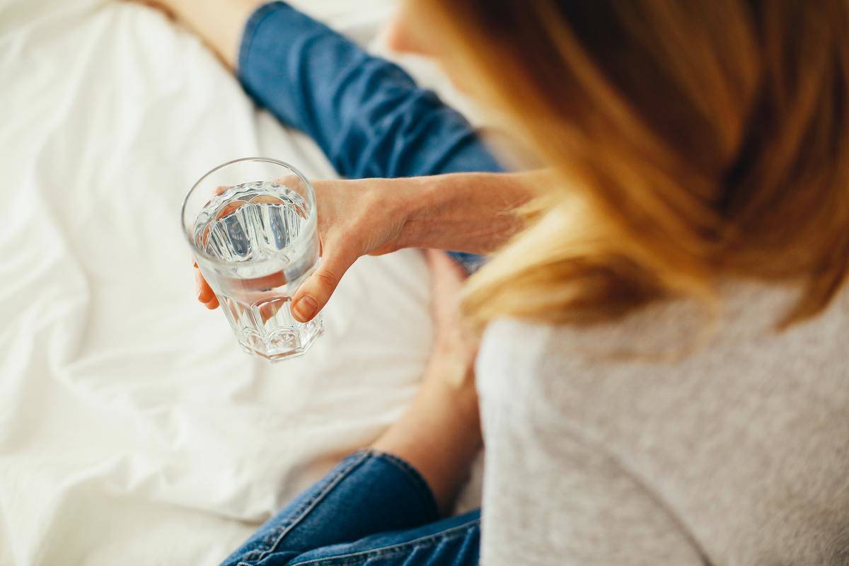 A woman holding a glass of water