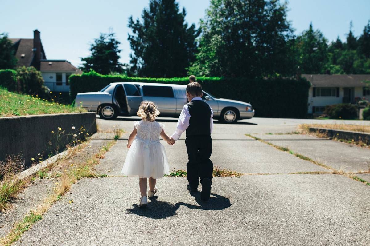 A boy and girl holding hands at a wedding.