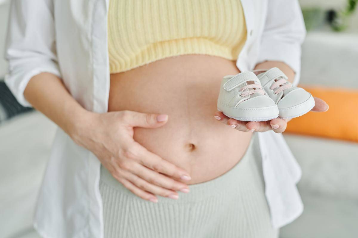 Stock photo woman holding baby's shoes