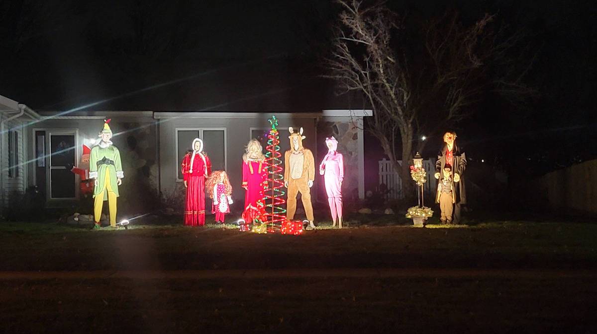 mannequins standing on lawn for Christmas display during dark night