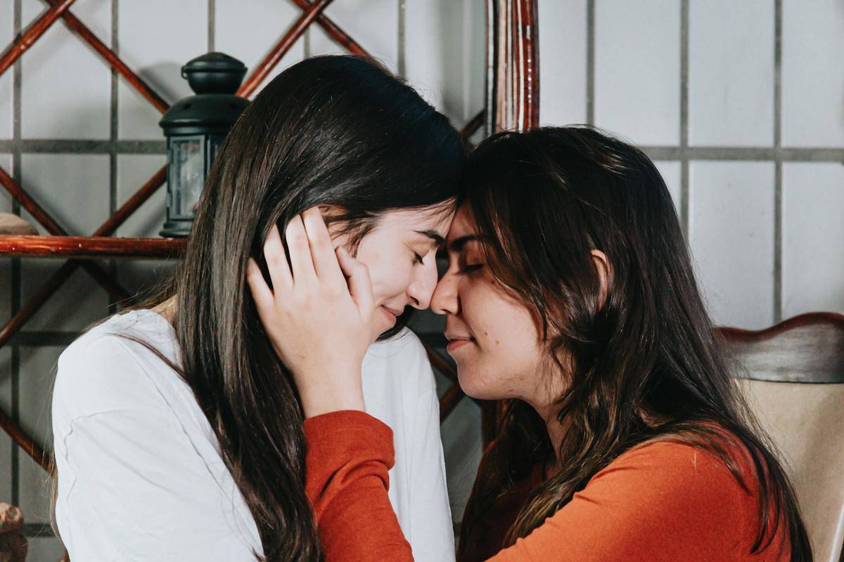 women touching their noses together in loving embrace