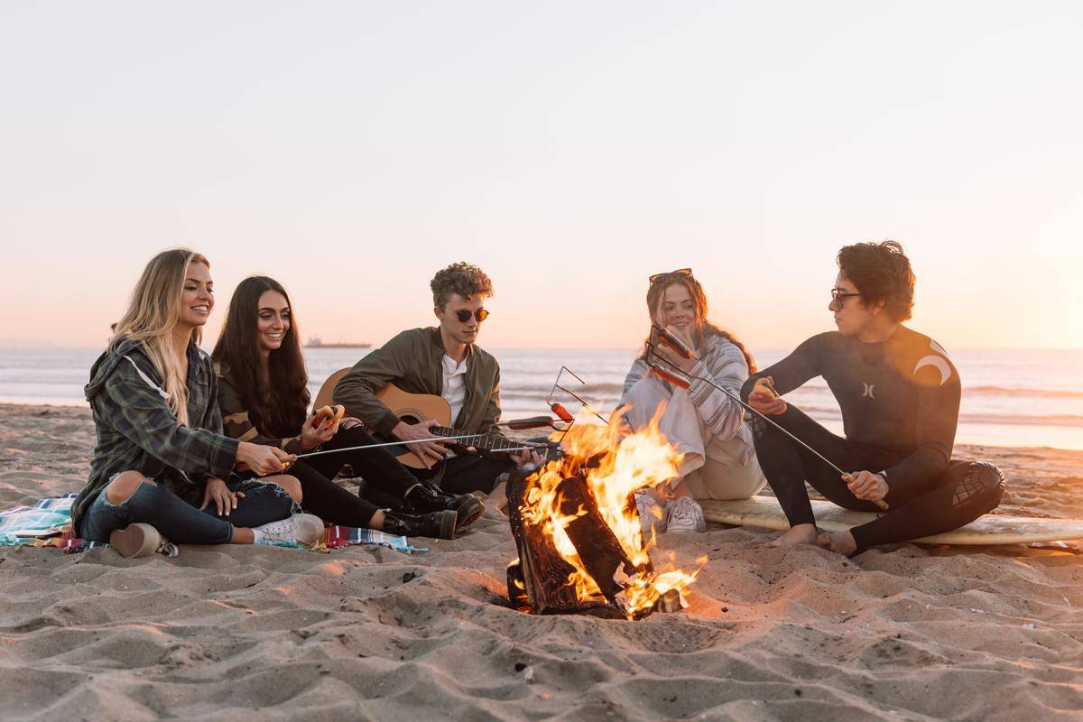 teens sitting around a campfire at the beach
