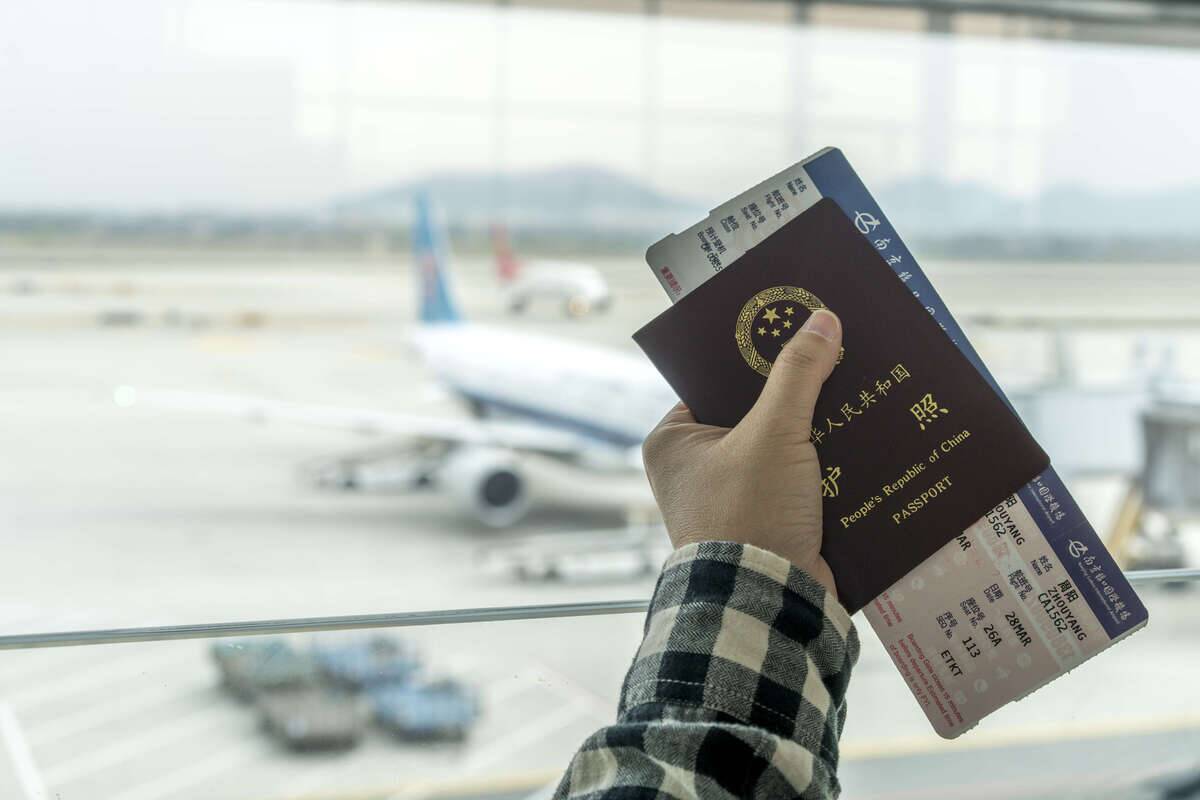 A passenger holds ticket and passport, waiting for boarding...