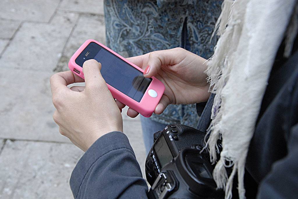 woman using her iphone with a pink case