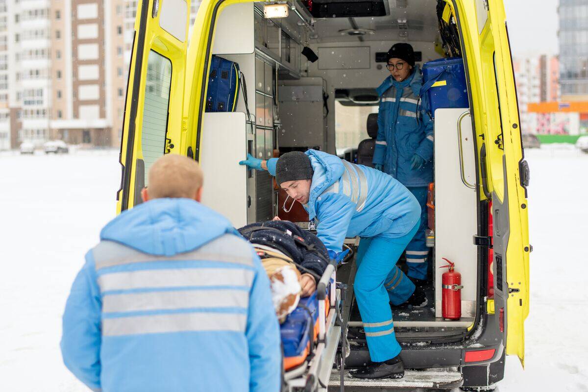 paramedics loading person into ambulance