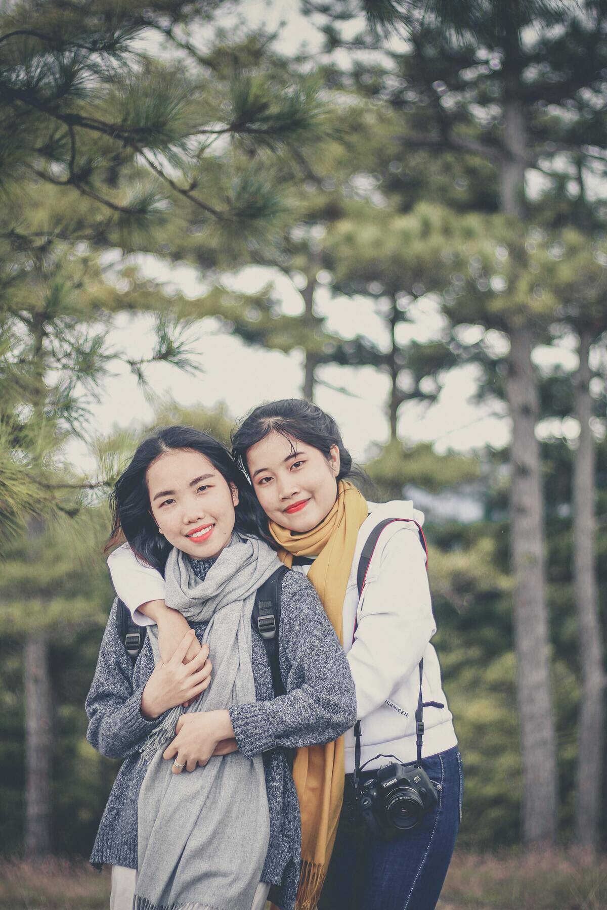 sisters embarcing while posing and looking at camera