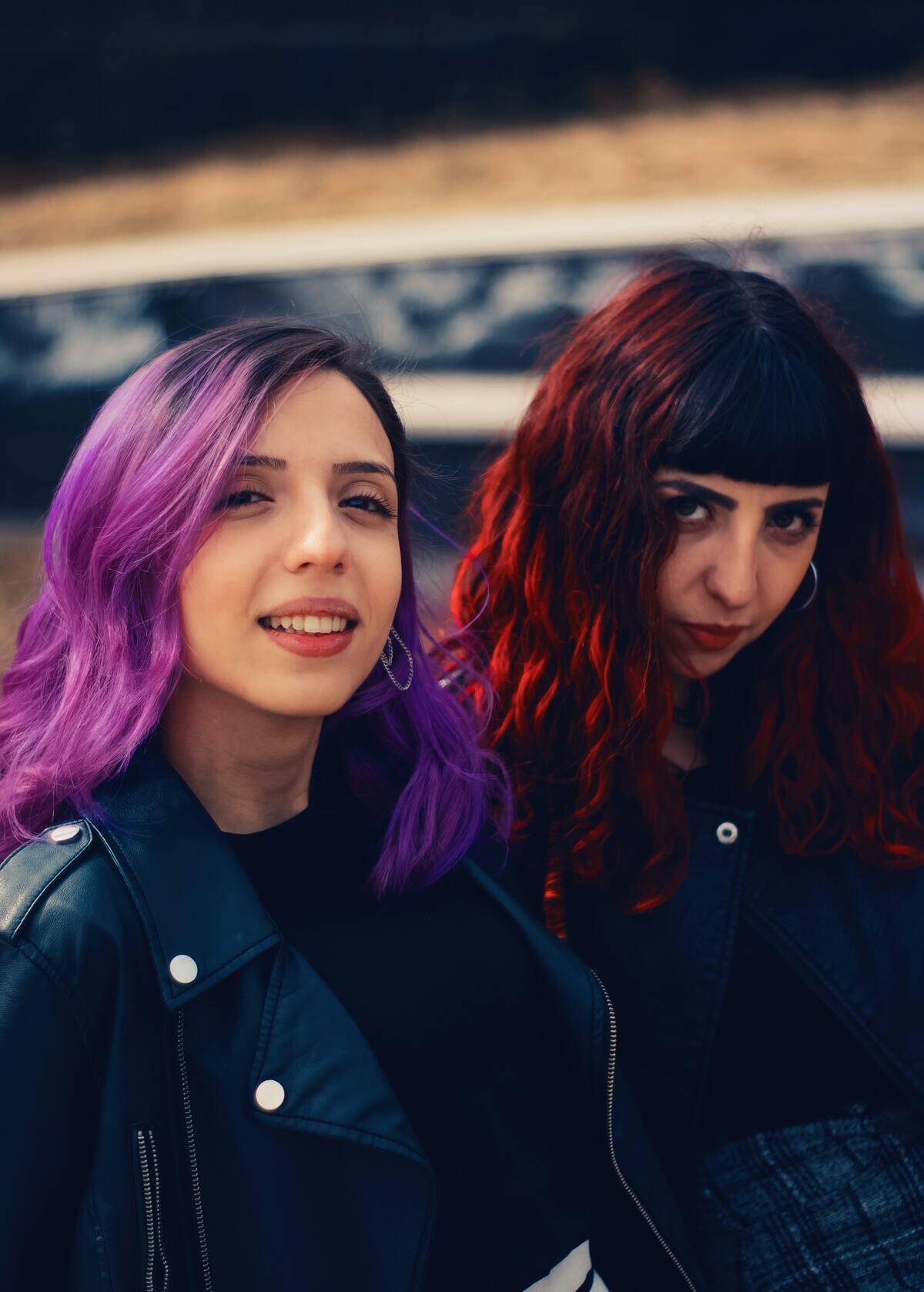sisters with purple and red hair standing next to each other