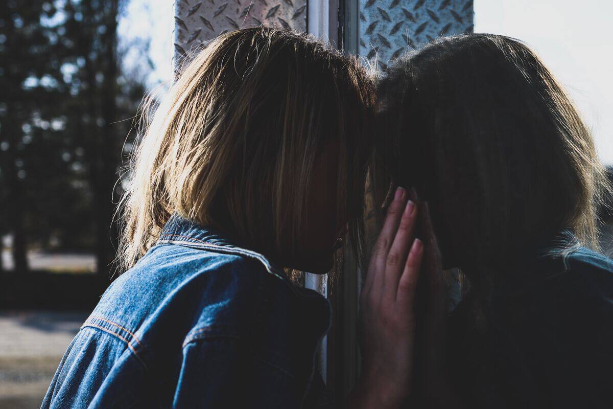 woman pressing her head against large window