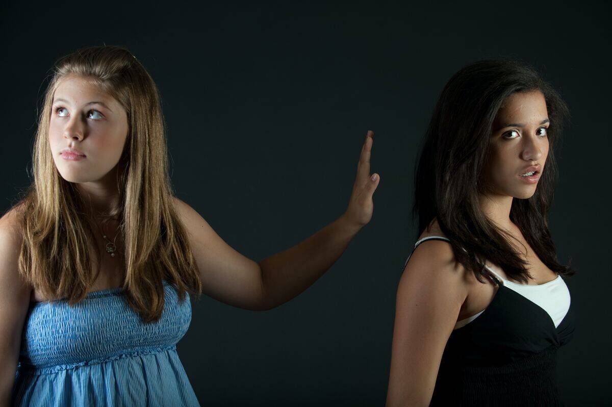 young woman dismissing other young woman