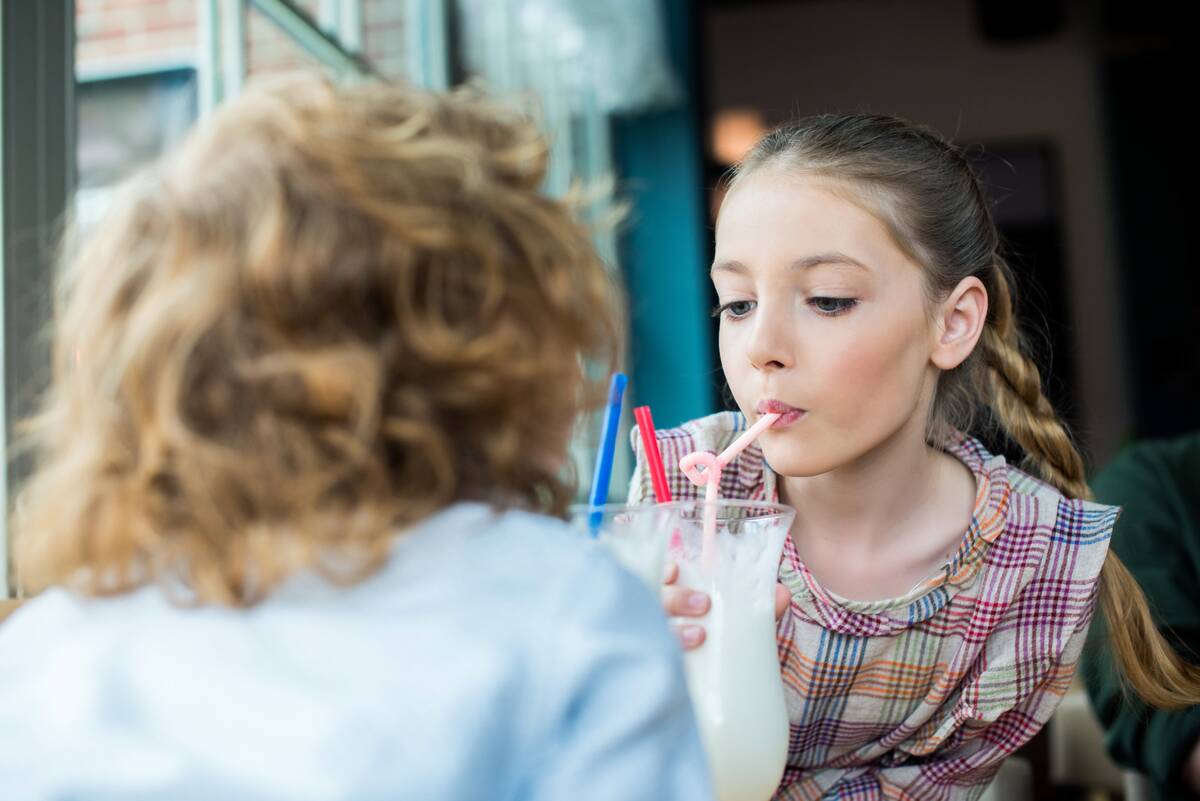 adorable-kids-drinking-milkshake-from-glass-with-c-2022-12-16-17-48-18-utc