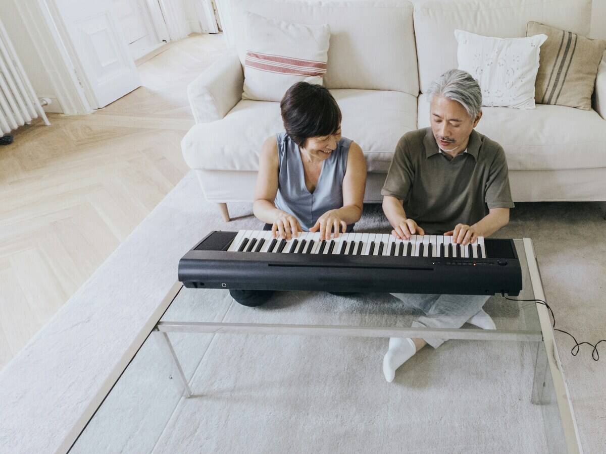A couple playing a keyboard together