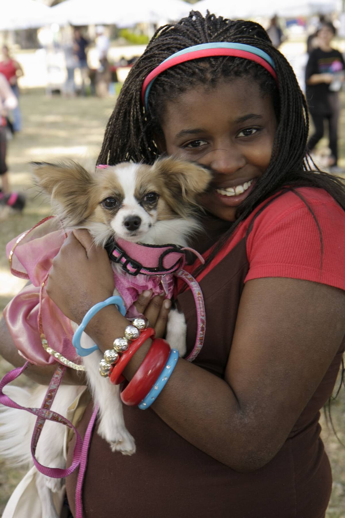 A girl holding her pet dog at the Dogs On The Catwalk in Legion Park