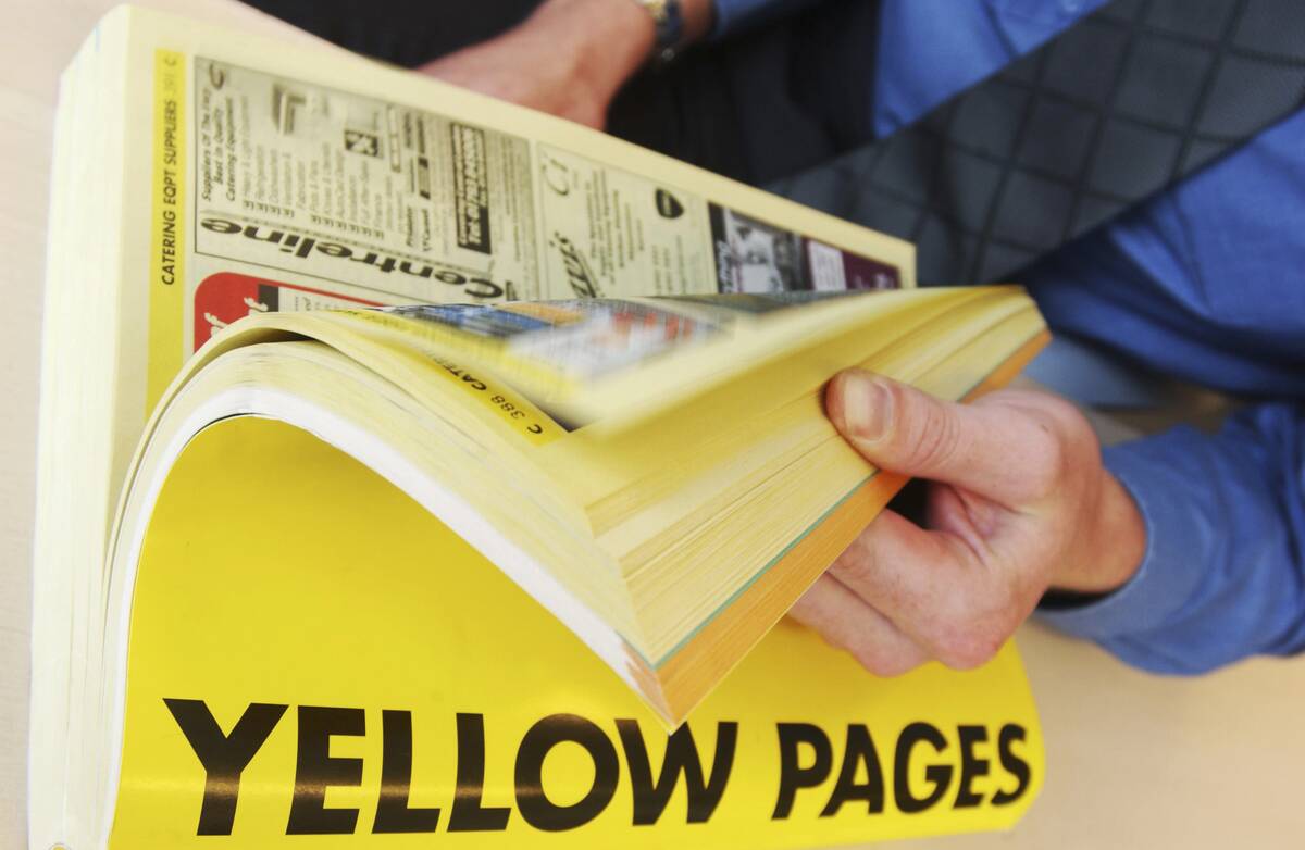 A man using the Yellow Pages telephone Directory