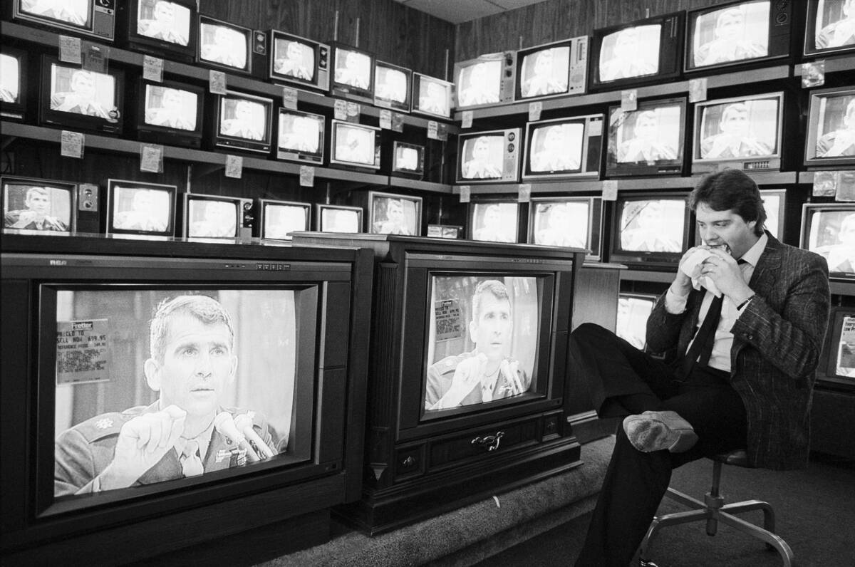 Salesman Eats,Watches Oliver North On Tv