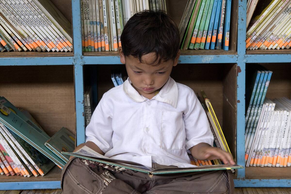 A child reads a book in a library run by the NGO Library For...