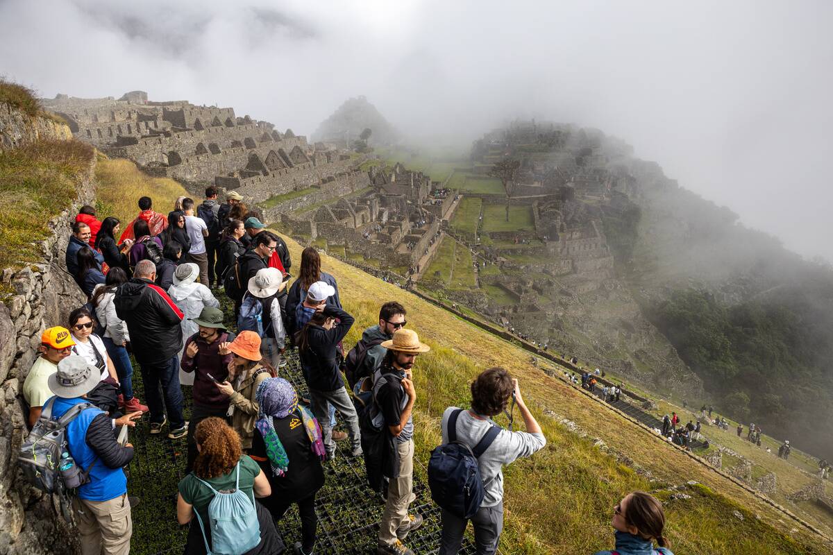 A group of tourists wait for fog to clear, so they can take...