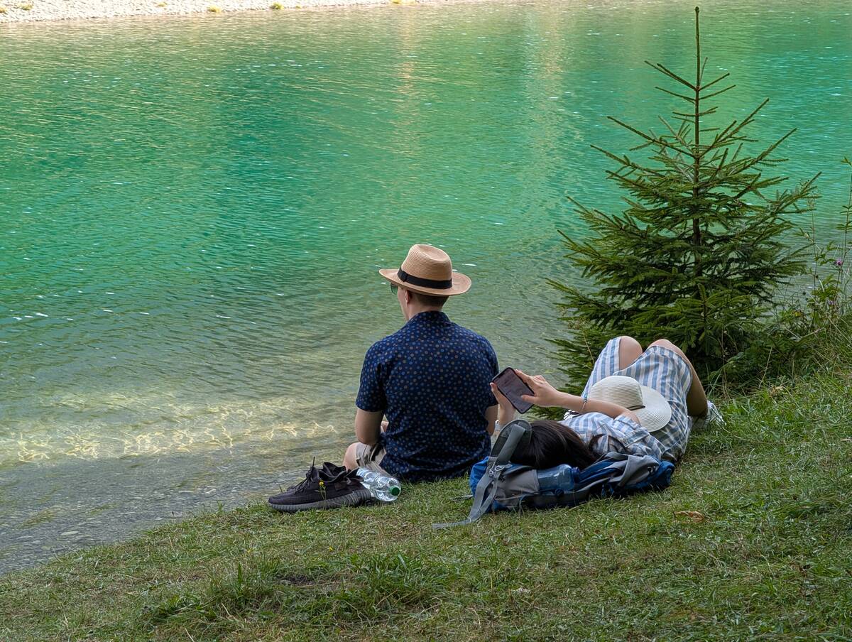 Couple With Smartphone By Water In Summer