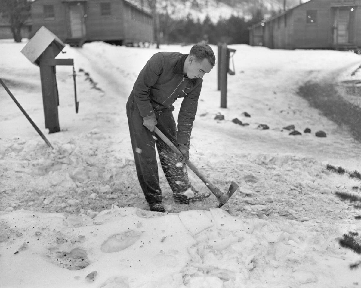 Man Breaking Ice With a Pickaxe