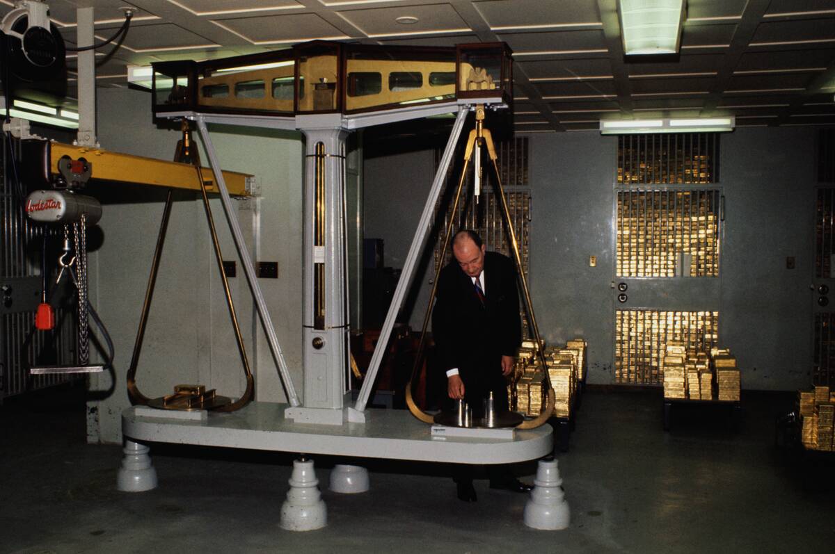 Man Weighing Gold Bars on a Scale