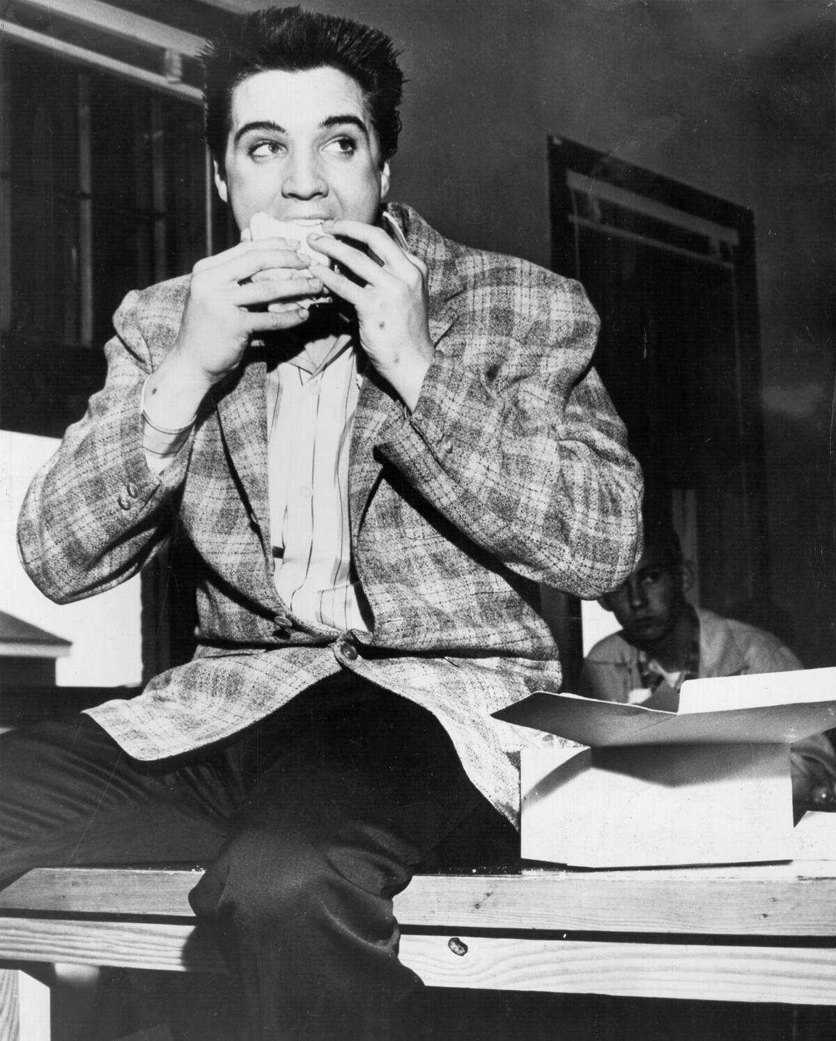 Rock and roll singer Elvis Presley gets his first taste of Army food