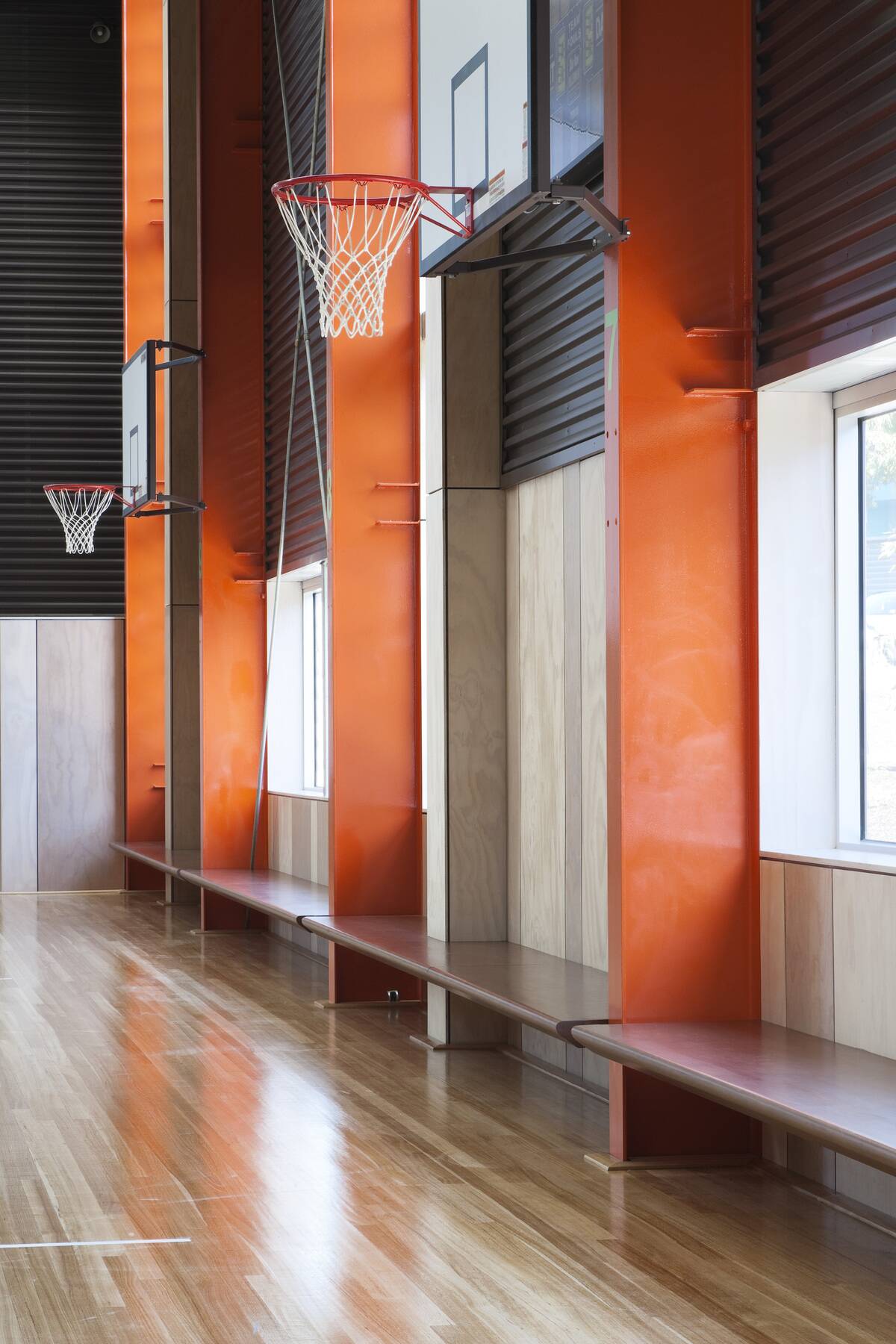 Detail of multi-purpose stadium with basketball rings. MPARC (Monash Peninsula Activity and Recreation Centre), Frankston, Australia. Architect: Harmer Architecture, 2012.