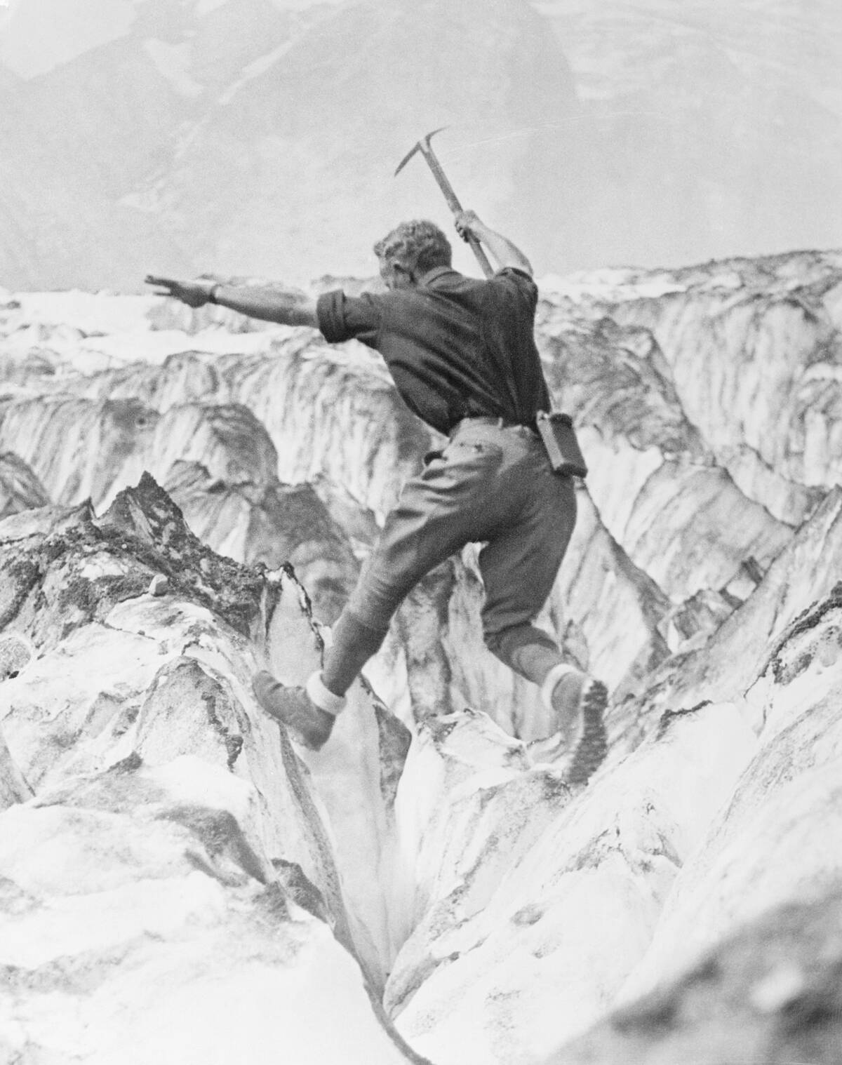 Man Jumping Across Glacier Crevasse