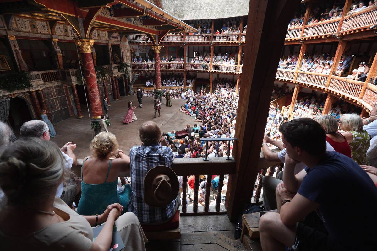 Theatregoers Enjoy The Sunshine During A Performance At The Globe