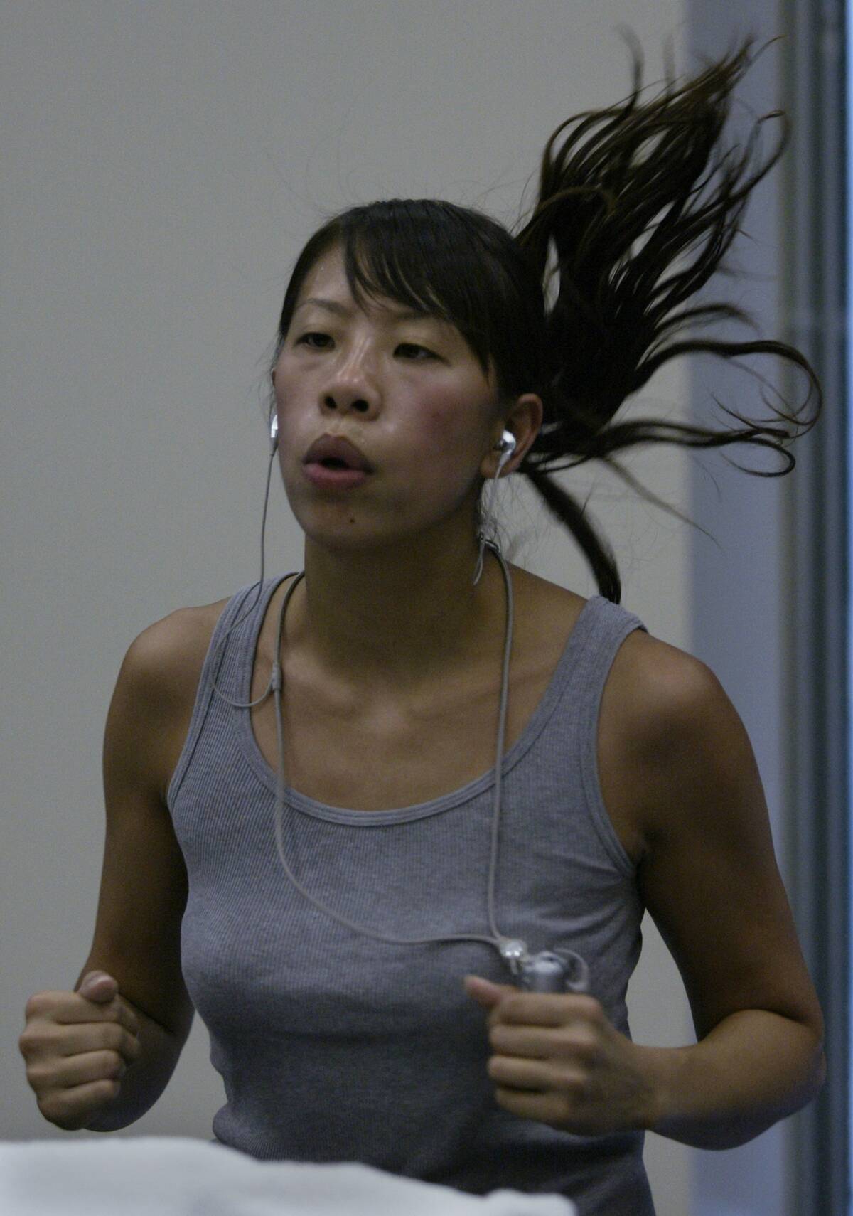 06/16/2005.Michelle Wong age 26 from LA listens to MP3 as she runs on a treadmill at Meridian Sport