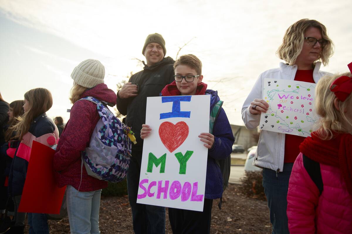 An elementary school student holding a placard in support of...