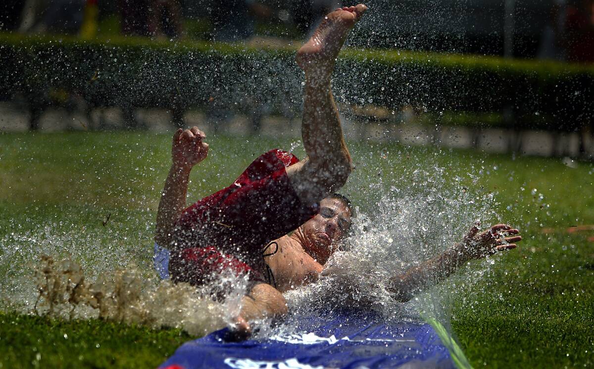 Chapman University Associated Students president, Bryan Lovell, 21, beats the heat by sliding down t