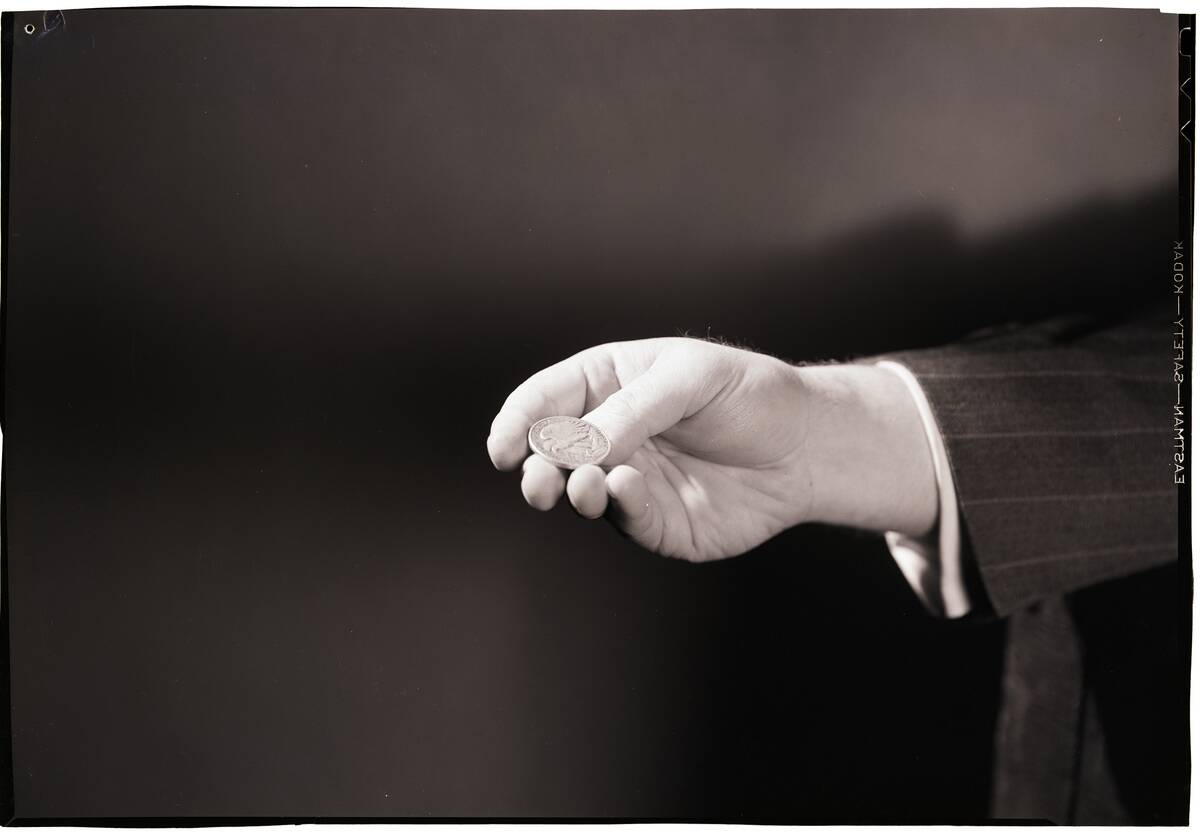 Close-Up Of Man's Hand Flipping Coin