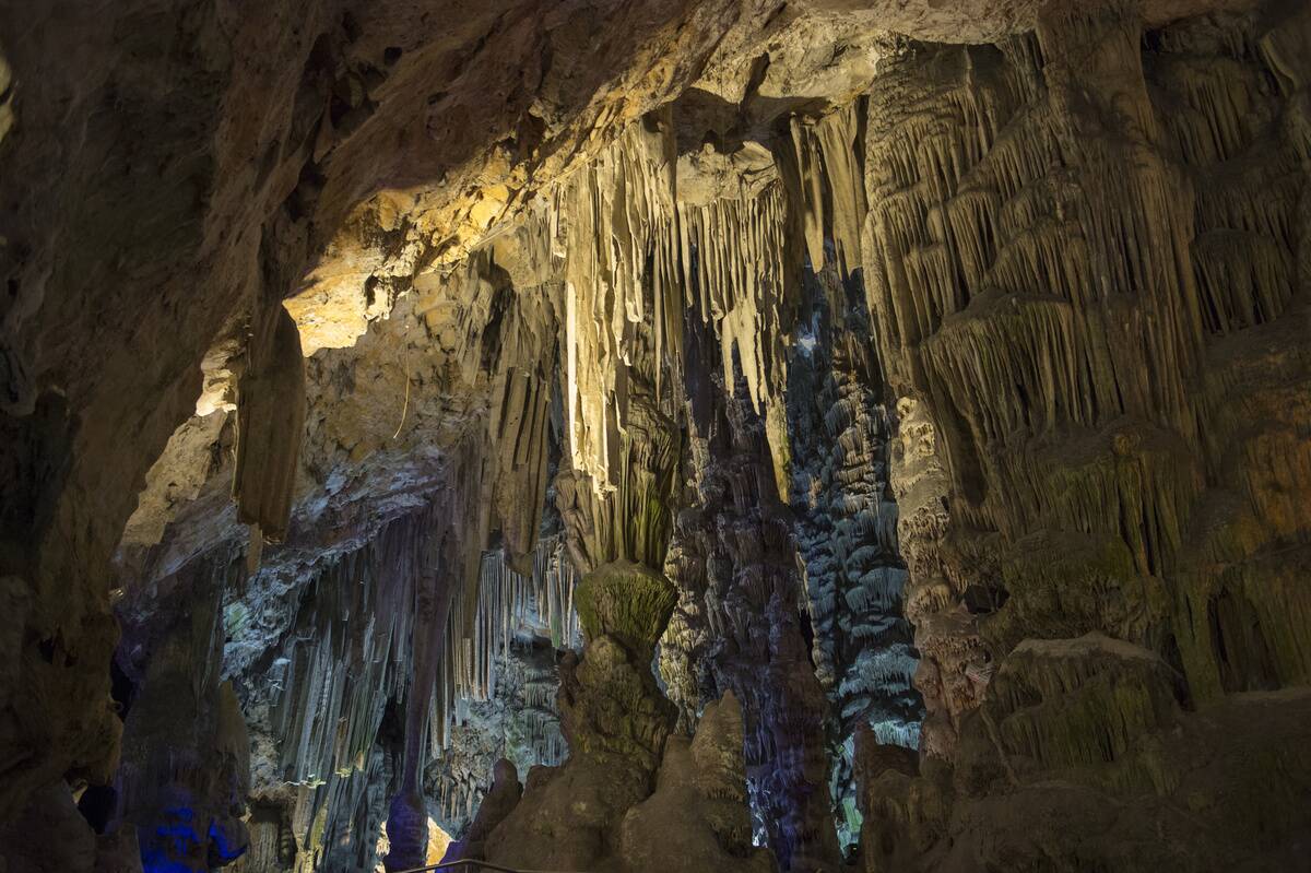 Colorful lights illuminate the stalactites and stalagmites...