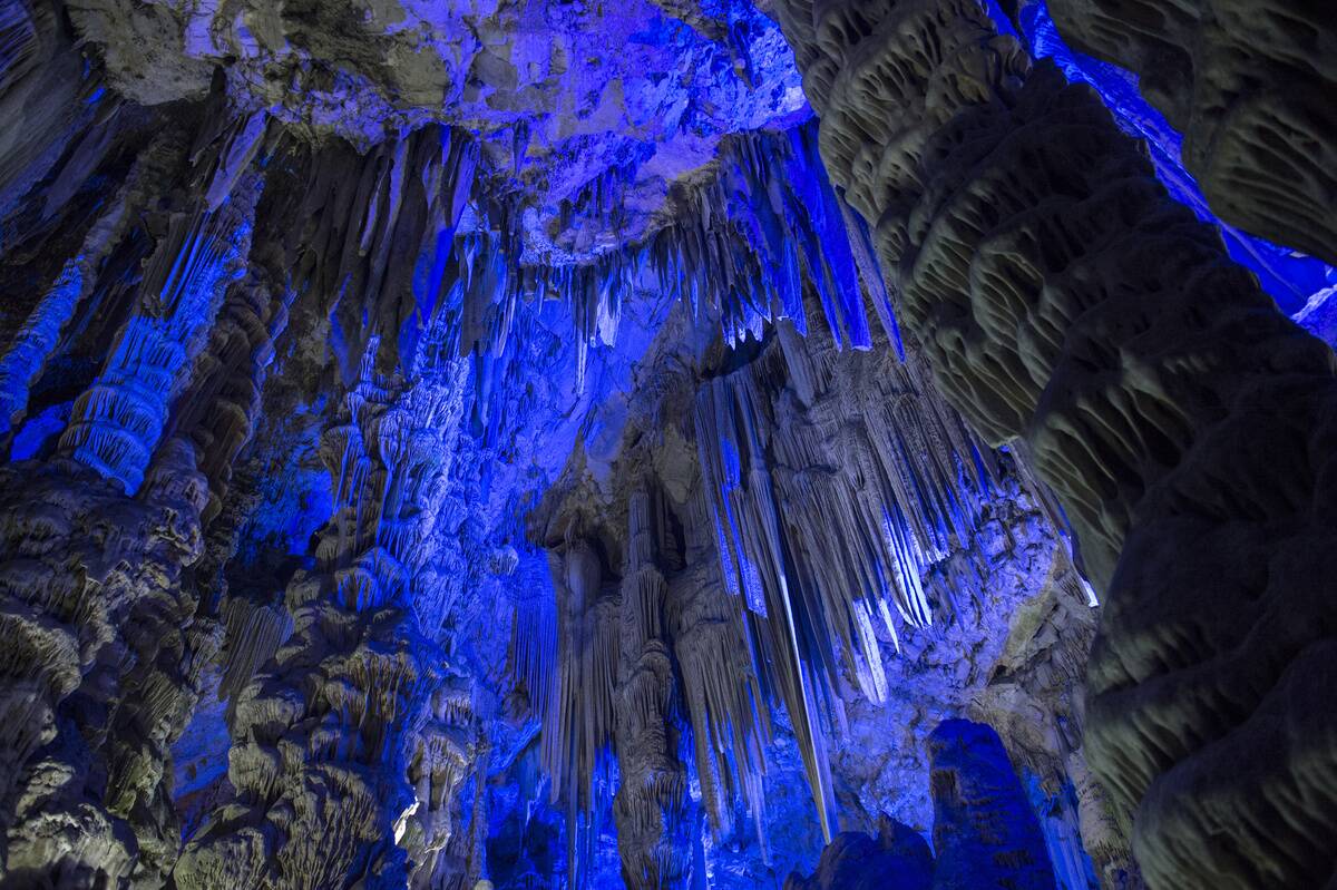 Colorful lights illuminate the stalactites and stalagmites...