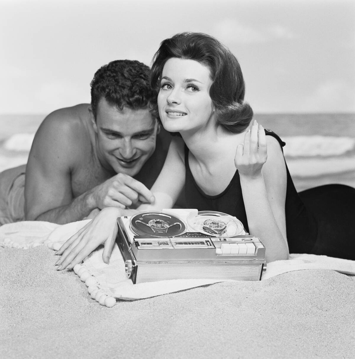 Couple listening music on beach, close-up